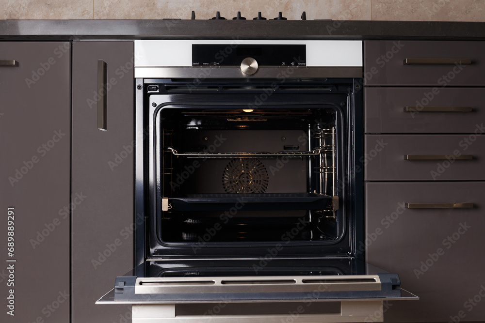 Fototapeta premium Built-in electric oven with open door in the kitchen.
