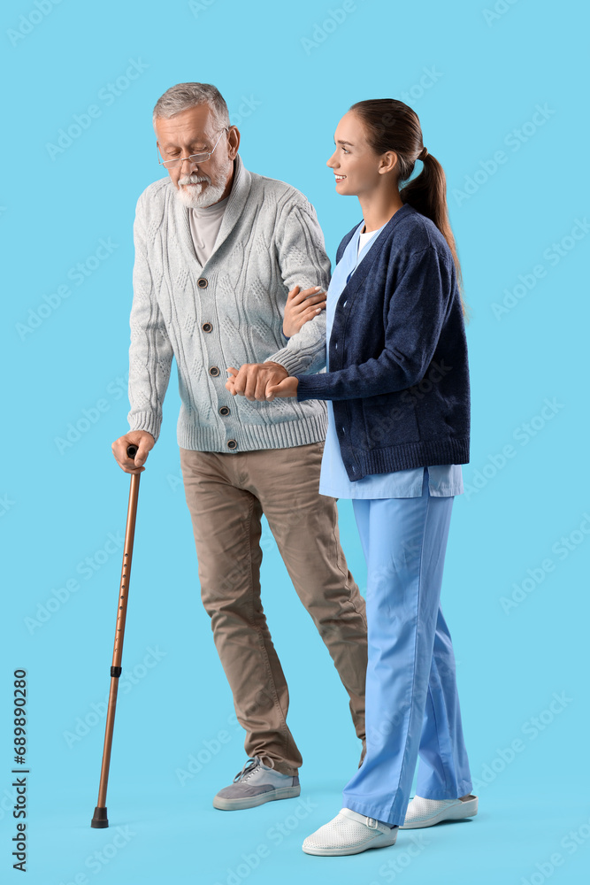 Senior man with walking stick and nurse on blue background Senior man with walking stick and nurse on blue background