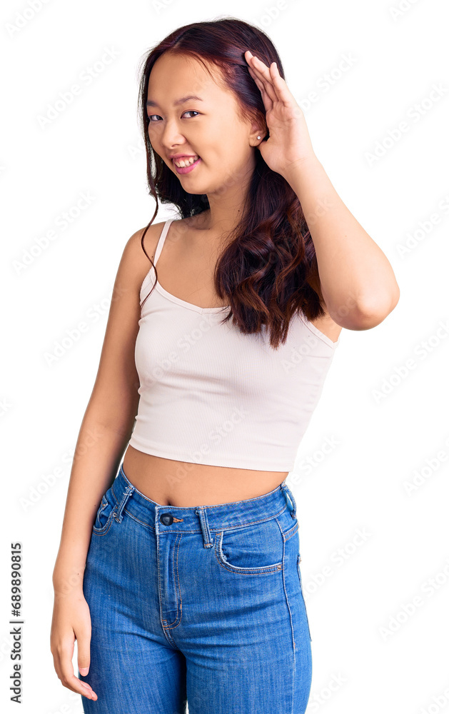 Young beautiful chinese girl wearing casual clothes smiling with hand over ear listening an hearing to rumor or gossip. deafness concept. Young beautiful chinese girl wearing casual clothes smiling with hand over ear listening an hearing to rumor or gossip. deafness concept.