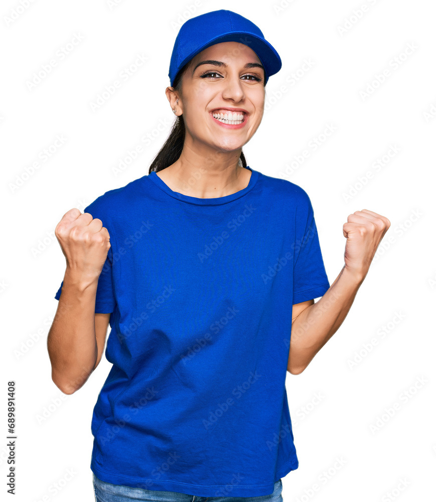 Young hispanic girl wearing delivery courier uniform celebrating surprised and amazed for success with arms raised and open eyes. winner concept. Young hispanic girl wearing delivery courier uniform celebrating surprised and amazed for success with arms raised and open eyes. winner concept.