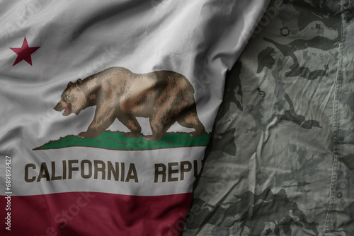 waving flag of california state on the old khaki texture background. military concept. photo