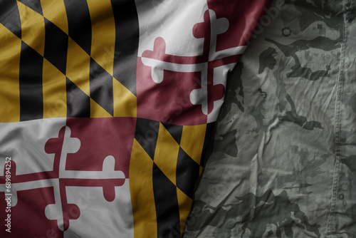 waving flag of maryland state on the old khaki texture background. military concept.