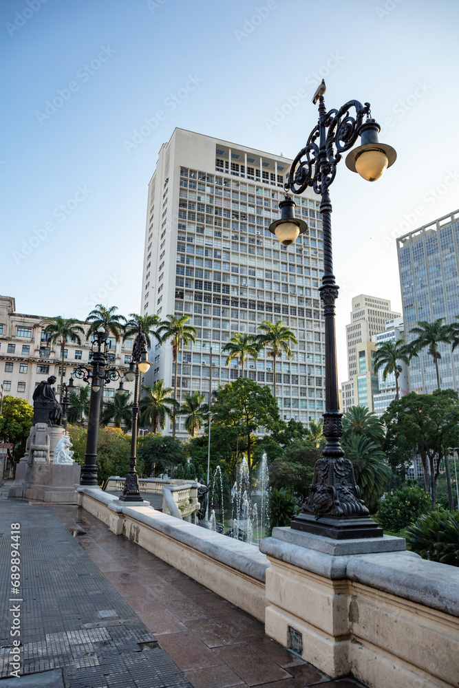Fototapeta premium Sunrise over Tea Viaduct(Viaduto do Cha) in downtown with palm trees in the background, Sao Paulo city in Brazil