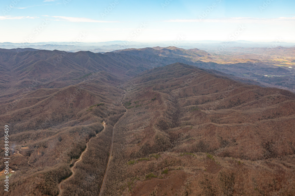 Aerial view of barren mountains and roads in the winter time