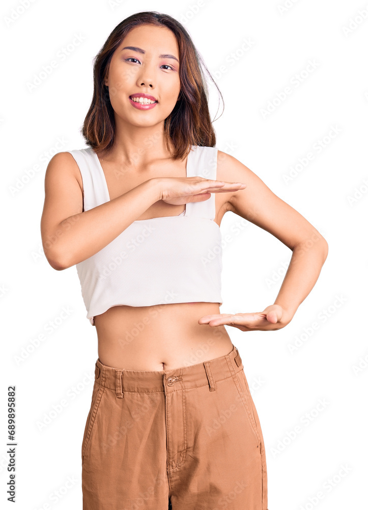Φωτογραφία Young beautiful chinese girl wearing casual clothes gesturing with hands showing big and large size sign, measure symbol