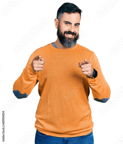 Hispanic man with beard wearing casual winter sweater pointing fingers to camera with happy and funny face. good energy and vibes.
