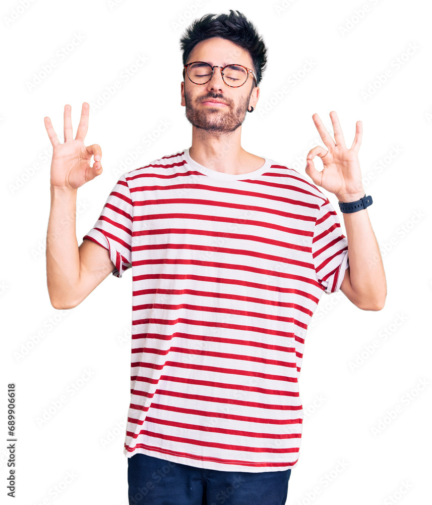 Young hispanic man wearing casual clothes relaxed and smiling with eyes closed doing meditation gesture with fingers. yoga concept. Young hispanic man wearing casual clothes relaxed and smiling with eyes closed doing meditation gesture with fingers. yoga concept.