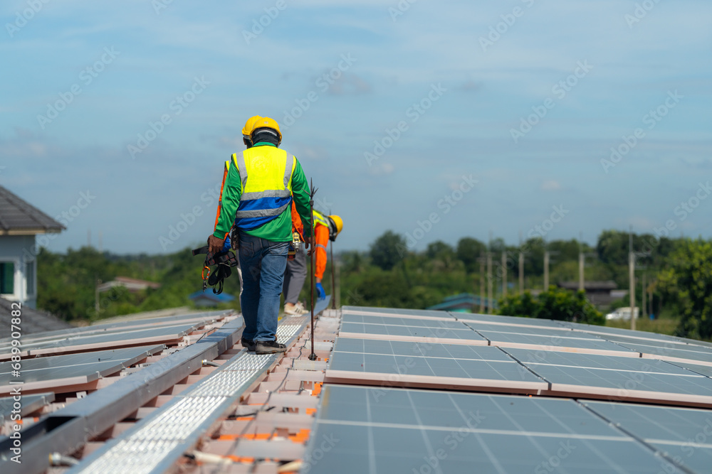 Worker Technicians are working to construct solar panels system on roof. Installing solar photovoltaic panel system. Alternative energy ecological concept. Renewable clean energy technology concept. Worker Technicians are working to construct solar panels system on roof. Installing solar photovoltaic panel system. Alternative energy ecological concept. Renewable clean energy technology concept.