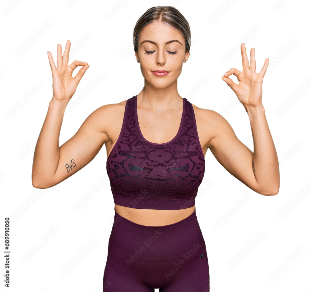 Beautiful blonde woman wearing sportswear relax and smiling with eyes closed doing meditation gesture with fingers. yoga concept. Beautiful blonde woman wearing sportswear relax and smiling with eyes closed doing meditation gesture with fingers. yoga concept.