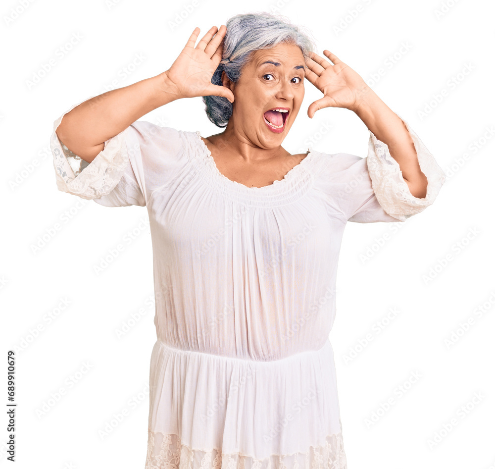 Senior woman with gray hair wearing bohemian style smiling cheerful playing peek a boo with hands showing face. surprised and exited Senior woman with gray hair wearing bohemian style smiling cheerful playing peek a boo with hands showing face. surprised and exited