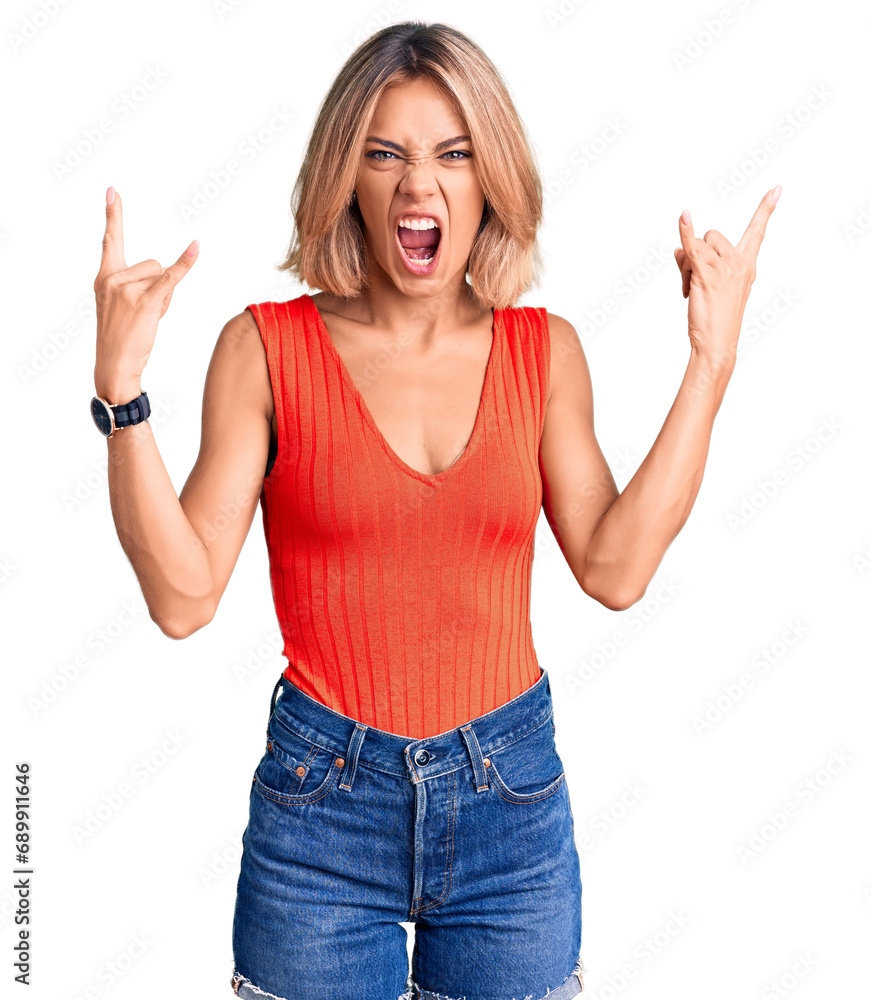 Beautiful caucasian woman wearing casual clothes shouting with crazy expression doing rock symbol with hands up. music star. heavy concept. Beautiful caucasian woman wearing casual clothes shouting with crazy expression doing rock symbol with hands up. music star. heavy concept.
