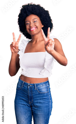 Young african american woman wearing casual clothes smiling looking to the camera showing fingers doing victory sign. number two.