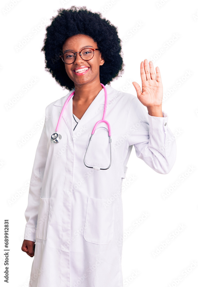 Young african american woman wearing doctor coat and stethoscope waiving saying hello happy and smiling, friendly welcome gesture