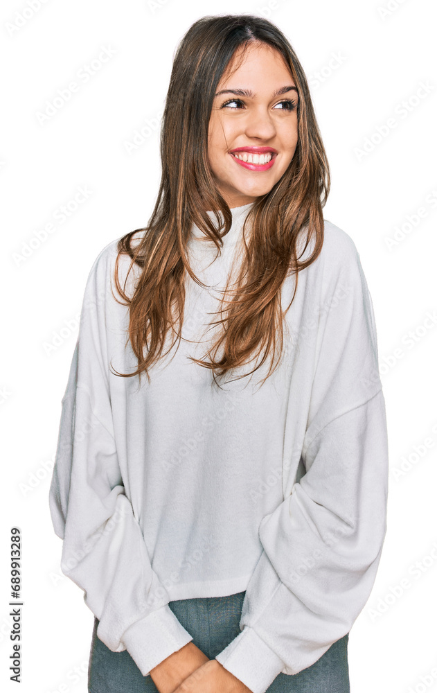 Young brunette woman wearing casual turtleneck sweater looking away to side with smile on face, natural expression. laughing confident. Young brunette woman wearing casual turtleneck sweater looking away to side with smile on face, natural expression. laughing confident.