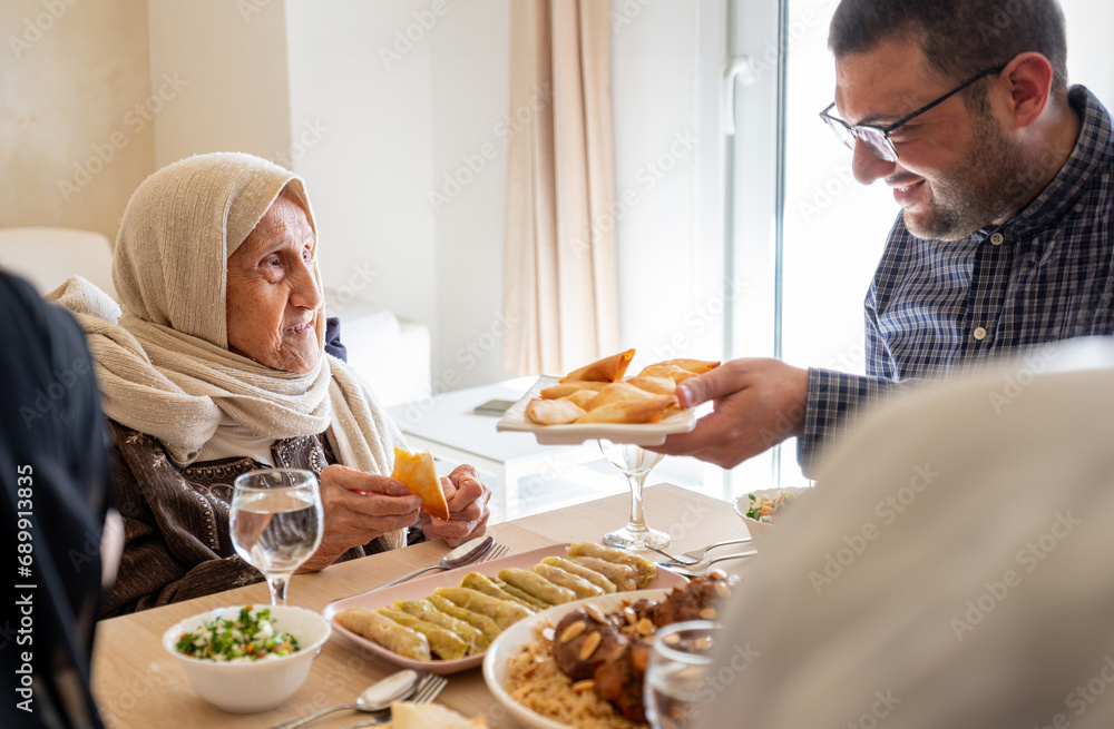 Family eating together with multi generation members in modern living room Family eating together with multi generation members in modern living room