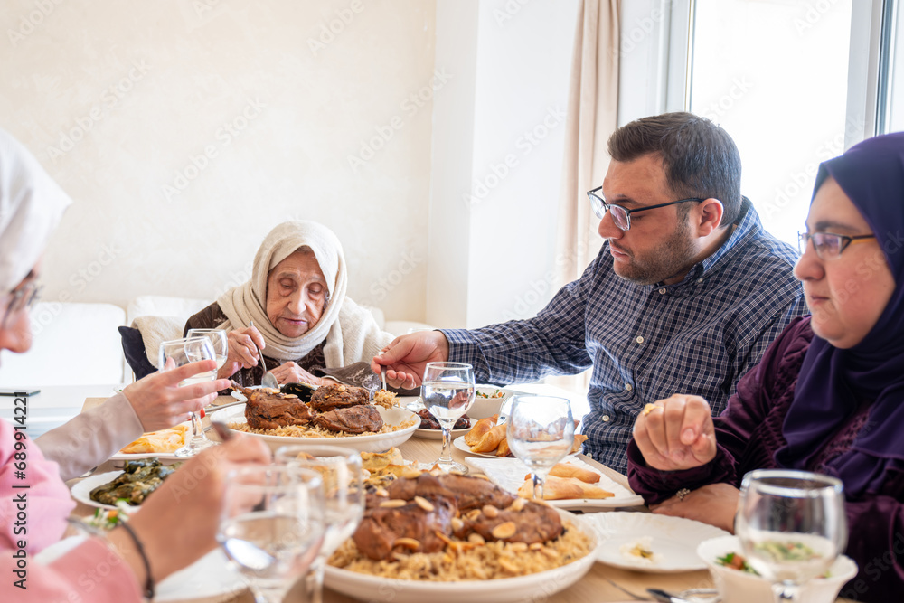 Family eating together with multi generation members in modern living room Family eating together with multi generation members in modern living room