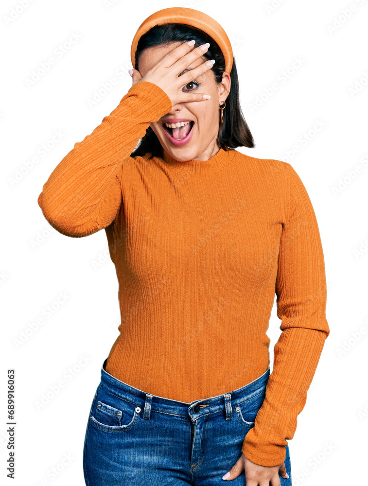 Young hispanic girl wearing casual white t shirt peeking in shock covering face and eyes with hand, looking through fingers with embarrassed expression. Young hispanic girl wearing casual white t shirt peeking in shock covering face and eyes with hand, looking through fingers with embarrassed expression.