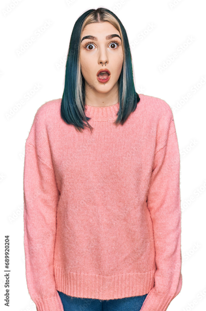 Young modern girl wearing pink wool winter sweater afraid and shocked with surprise expression, fear and excited face. Young modern girl wearing pink wool winter sweater afraid and shocked with surprise expression, fear and excited face.