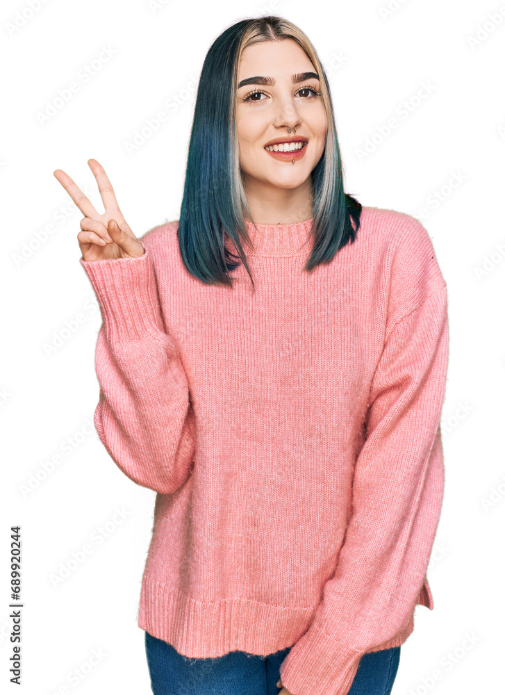 Young modern girl wearing pink wool winter sweater showing and pointing up with fingers number two while smiling confident and happy. Young modern girl wearing pink wool winter sweater showing and pointing up with fingers number two while smiling confident and happy.