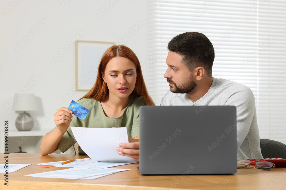 Couple with credit card using laptop for paying taxes online at home Couple with credit card using laptop for paying taxes online at home