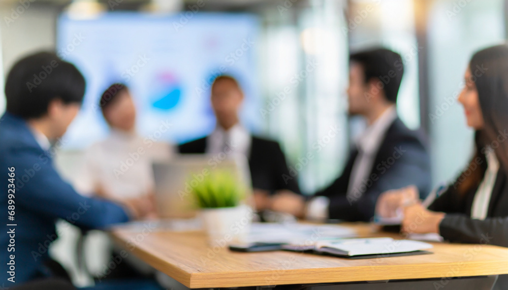 Blurred office meeting, businesspeople in boardroom discussing, representing collaboration and corporate teamwork Blurred office meeting, businesspeople in boardroom discussing, representing collaboration and corporate teamwork