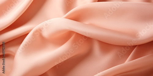 A close up view of a pink fabric. Monochrome peach fuzz background.