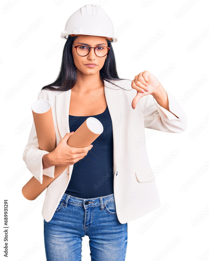 Young beautiful latin girl wearing architect hardhat holding blueprints with angry face, negative sign showing dislike with thumbs down, rejection concept Young beautiful latin girl wearing architect hardhat holding blueprints with angry face, negative sign showing dislike with thumbs down, rejection concept