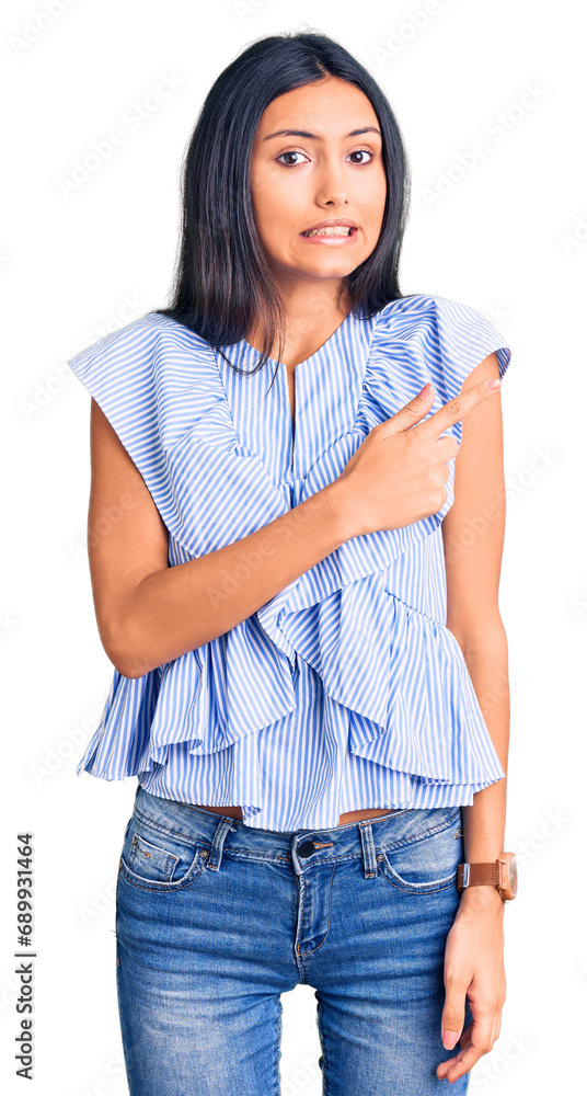 Young beautiful latin girl wearing casual clothes pointing aside worried and nervous with forefinger, concerned and surprised expression Young beautiful latin girl wearing casual clothes pointing aside worried and nervous with forefinger, concerned and surprised expression