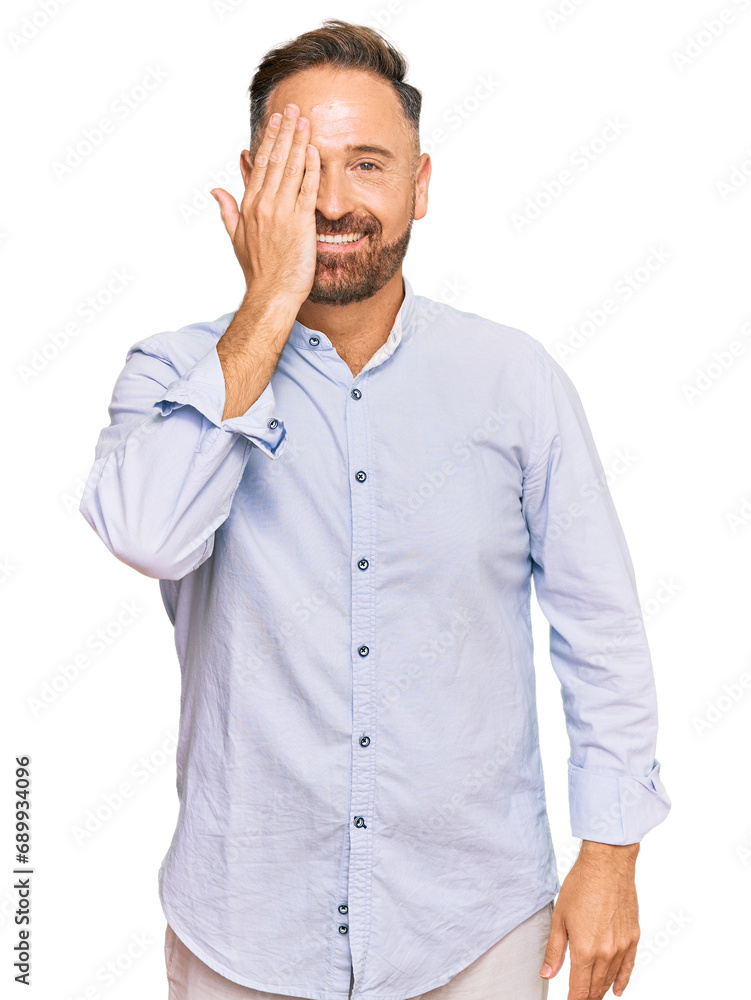 Handsome middle age man wearing business shirt covering one eye with hand, confident smile on face and surprise emotion. Handsome middle age man wearing business shirt covering one eye with hand, confident smile on face and surprise emotion.
