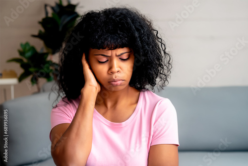 Black sad woman with hand on aching head