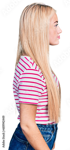 Beautiful blonde woman wearing casual striped t shirt looking to side, relax profile pose with natural face with confident smile.