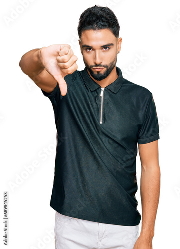 Young man with beard wearing sportswear looking unhappy and angry showing rejection and negative with thumbs down gesture. bad expression.