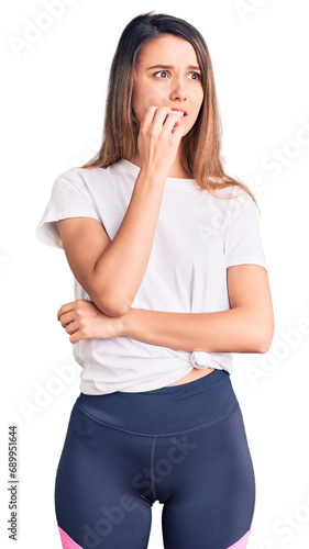 Young beautiful girl wearing casual t shirt looking stressed and nervous with hands on mouth biting nails. anxiety problem.