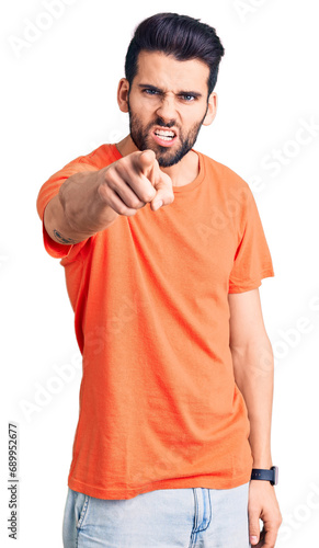 Young handsome man with beard wearing casual t-shirt pointing displeased and frustrated to the camera, angry and furious with you
