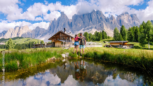 A couple of men and women at Geisleralm Rifugio Odle Dolomites Italy, men and woman hiking in the mountains of Val Di Funes in Italian Dolomites Adolf Munkel Trail in Puez Odle Nature Park photo