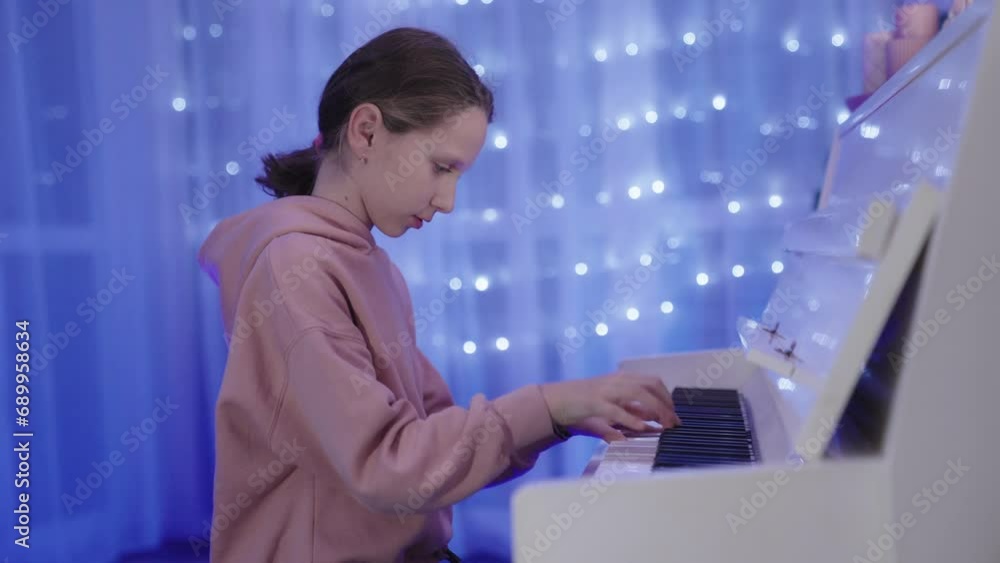 Talented pretty little girl plays white Piano with temperament. Live music scene with bright blurred bokeh. Talented pretty little girl plays white Piano with temperament. Live music scene with bright blurred bokeh.