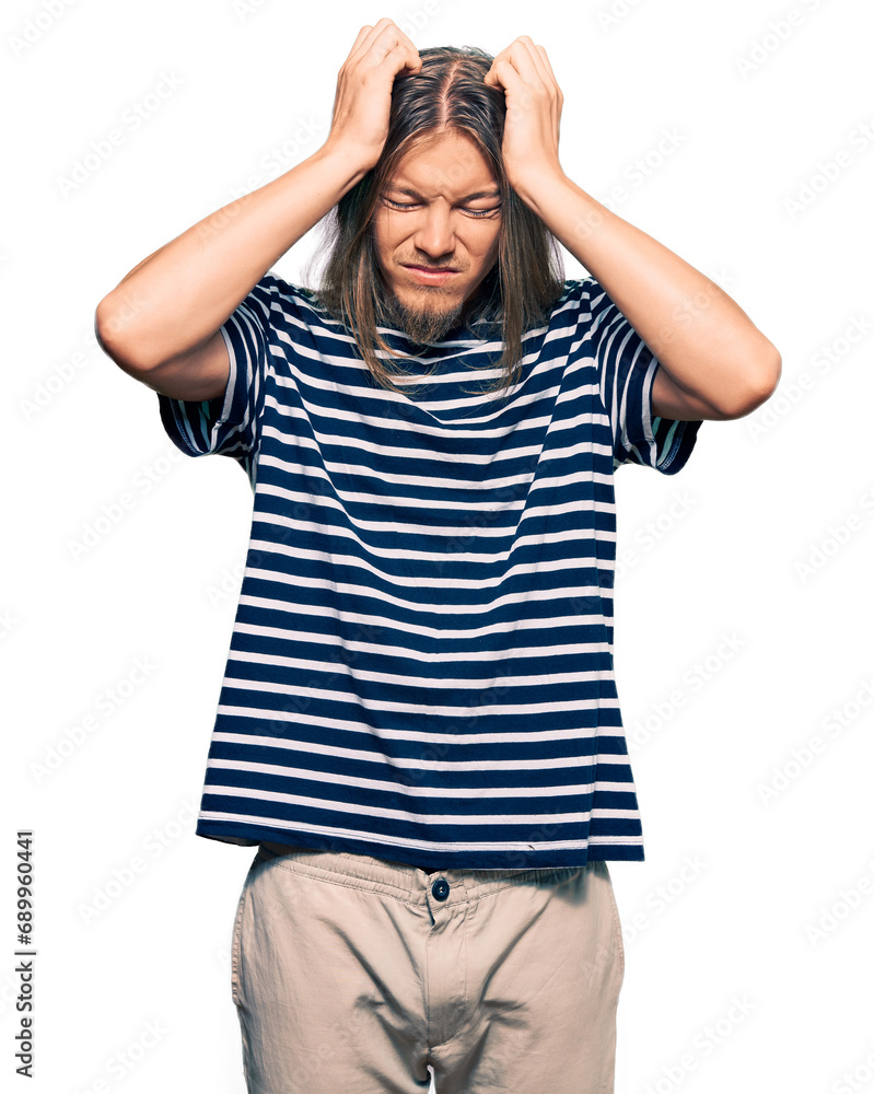 Handsome caucasian man with long hair wearing casual striped t-shirt suffering from headache desperate and stressed because pain and migraine. hands on head. Handsome caucasian man with long hair wearing casual striped t-shirt suffering from headache desperate and stressed because pain and migraine. hands on head.