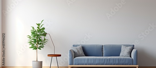 Simple living room interior with a blue sofa, grey lamp, wooden table, ficus, and ladder. photo