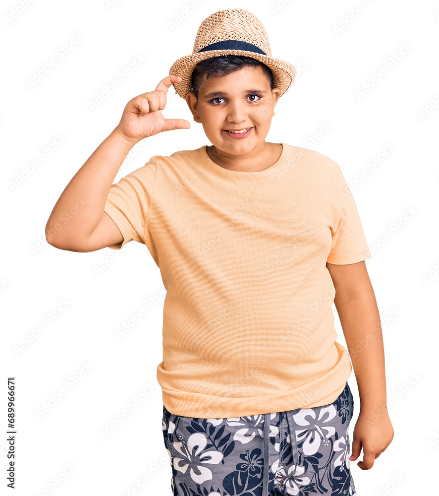 Little boy kid wearing summer hat and hawaiian swimsuit smiling and confident gesturing with hand doing small size sign with fingers looking and the camera. measure concept. Little boy kid wearing summer hat and hawaiian swimsuit smiling and confident gesturing with hand doing small size sign with fingers looking and the camera. measure concept.