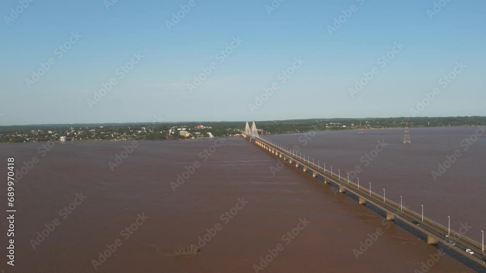 Aerial forward flight over Rio Paraná River with San Roque González de Santa Cruz Bridge during sunny day Aerial forward flight over Rio Paraná River with San Roque González de Santa Cruz Bridge during sunny day