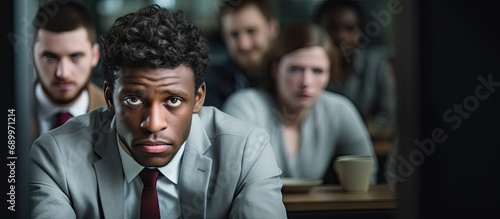 A young man experiences depression and isolation due to ridicule from coworkers, possibly due to racial discrimination. photo