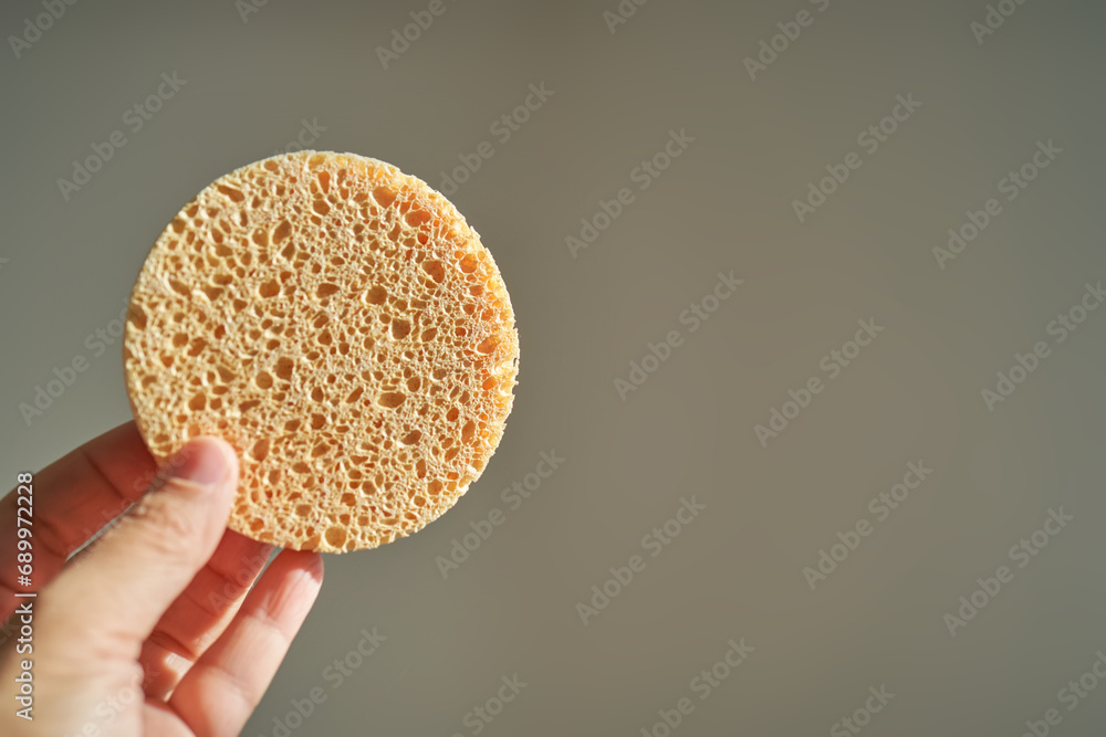 A large natural sponge in a womans hand. - obrazy, fototapety, plakaty 