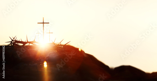 Silhouette of the cross and crown of thorns symbolizing the passion and great trials of Jesus Christ, and bright light and Holy Week and Easter background
