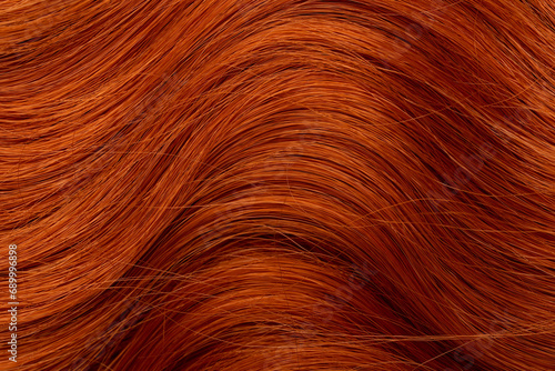 Red curly long hair close-up. A wave of hair as a background