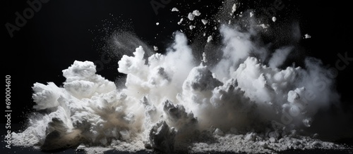 Stone debris explodes, scattering white powder against black backdrop.