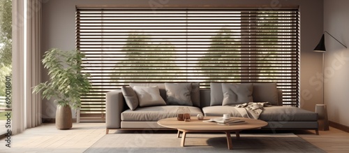 Modern living room with large wooden blinds, coffee table, and sleek grey sofa. photo