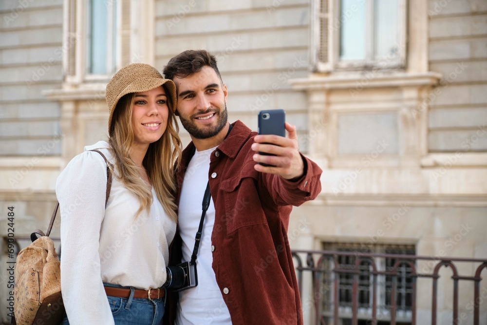 Young Caucasian couple taking a selfie while sightseeing the city of Madrid, Spain.