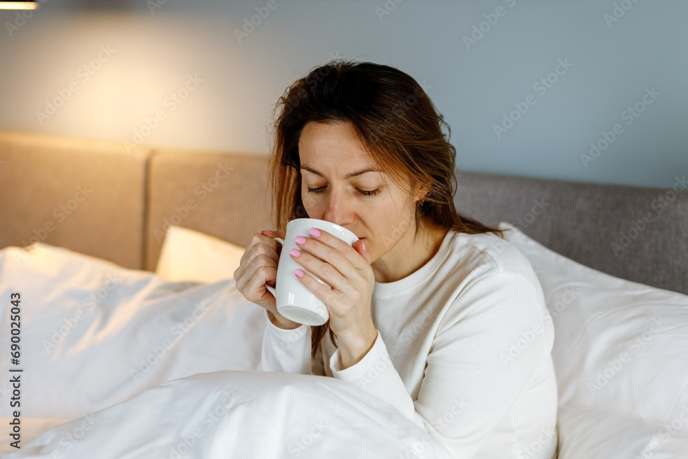 Portrait of woman with cup of beverage on bed Portrait of woman with cup of beverage on bed