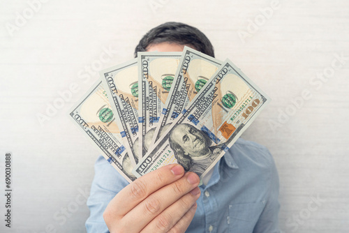 dollars in hands. Businessman in blue shirt holding a 500 dollars. a fan of money
