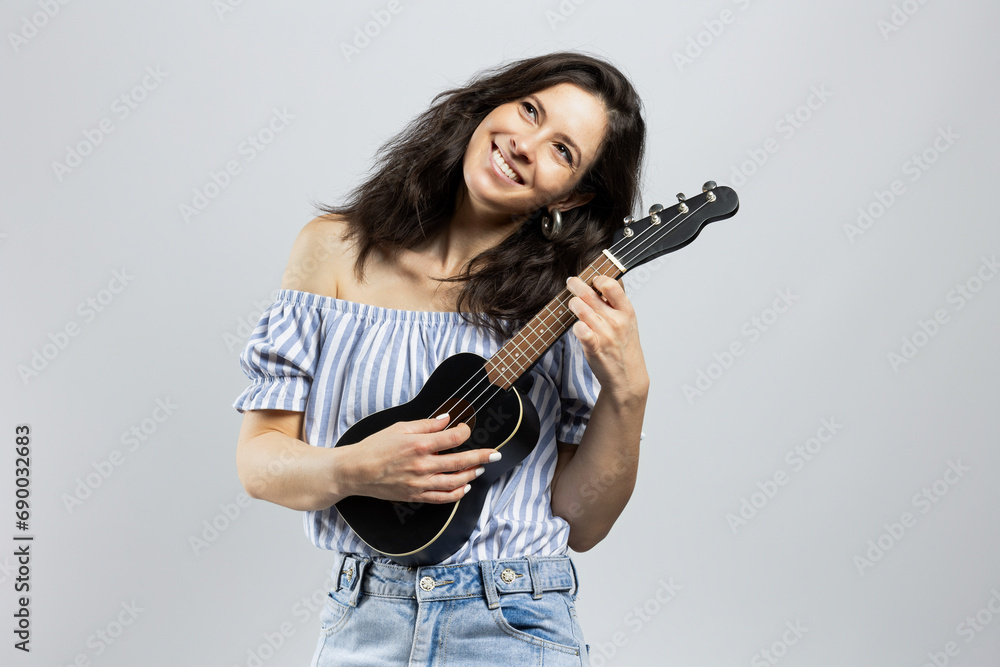Cute brunette playing ukulele Cute brunette playing ukulele